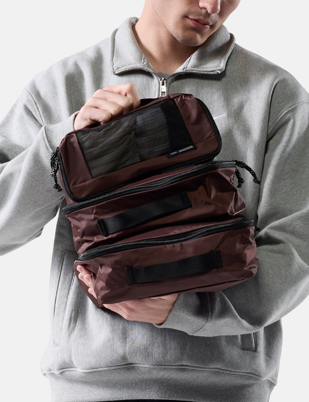 Person holding garnet packing cubes against a white background