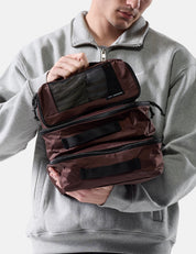 Person holding garnet packing cubes against a white background