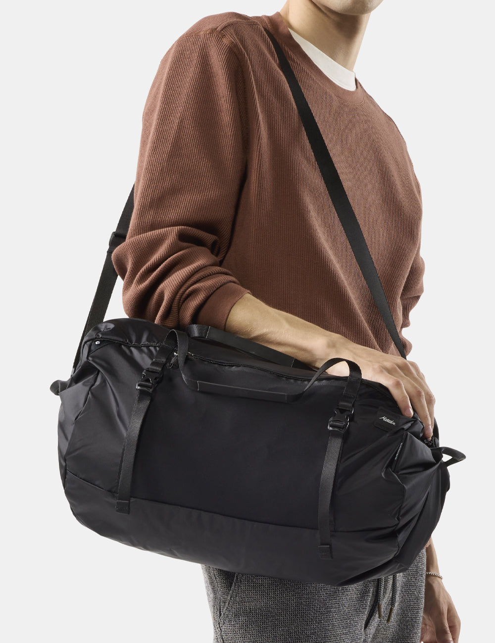 black duffel on person's shoulder