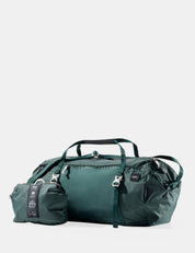 Green travel bag with smaller pouch on a light gray background