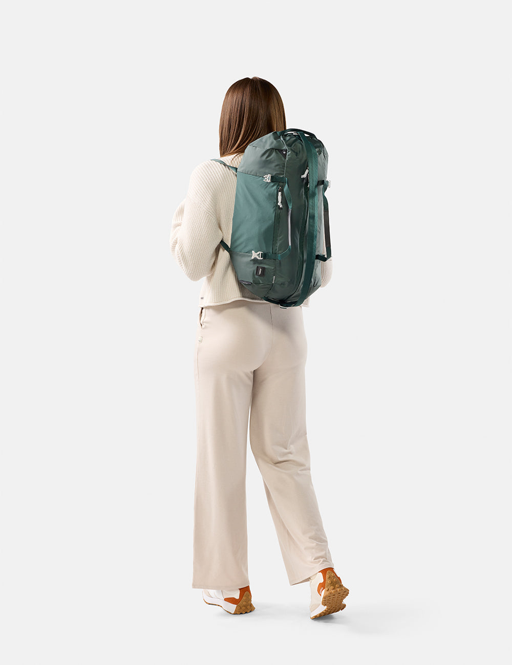 Person wearing a green backpack on a white background