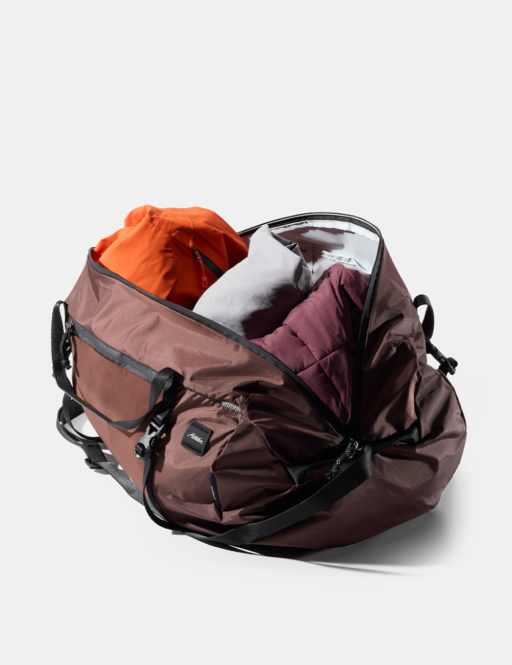 garnet duffel bag with orange and white items inside on a light gray background
