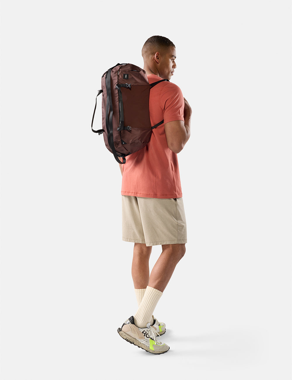 Man wearing a garnet backpack on a white background