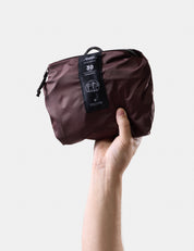Hand holding a garnet pack with a visible brand tag on a light gray background