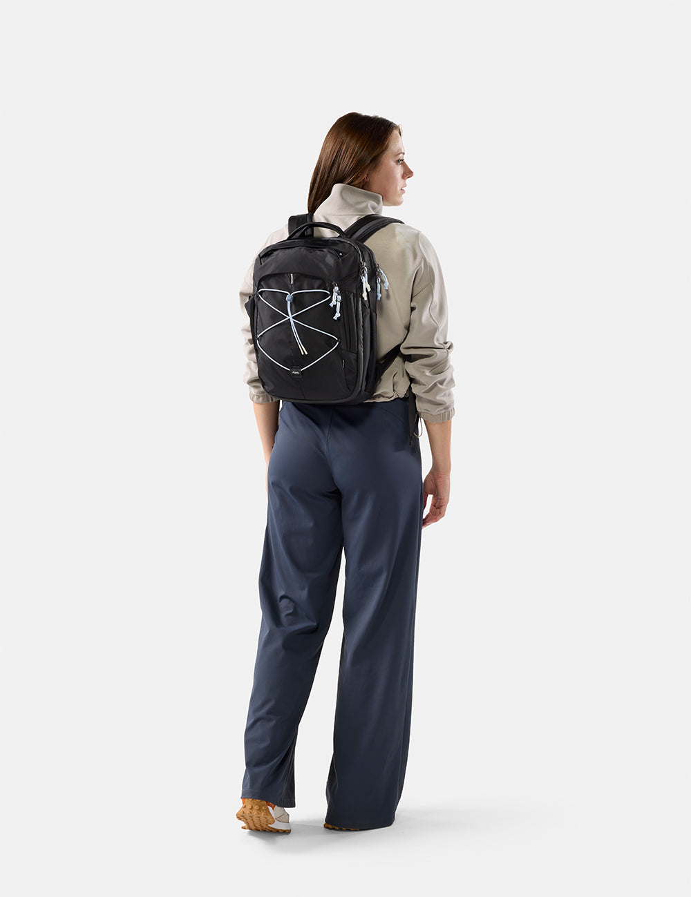 Person wearing a black backpack with a logo on a white background