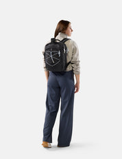 Person wearing a black backpack with a logo on a white background
