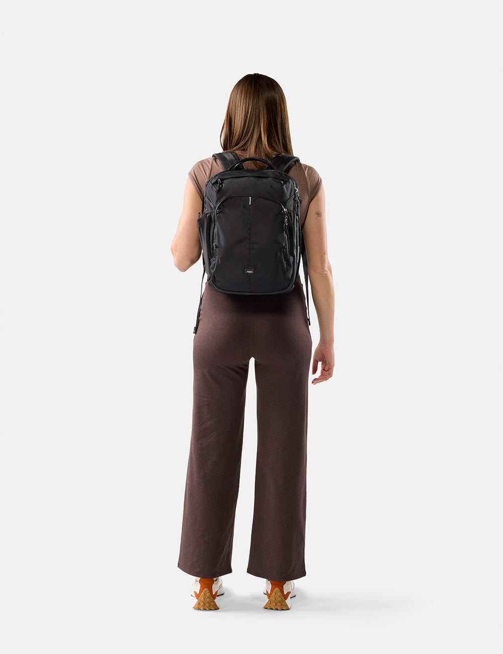 Person wearing a black backpack on a white background