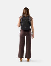 Person wearing a black backpack on a white background