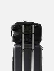 Black backpack and suitcase stacked on a white background