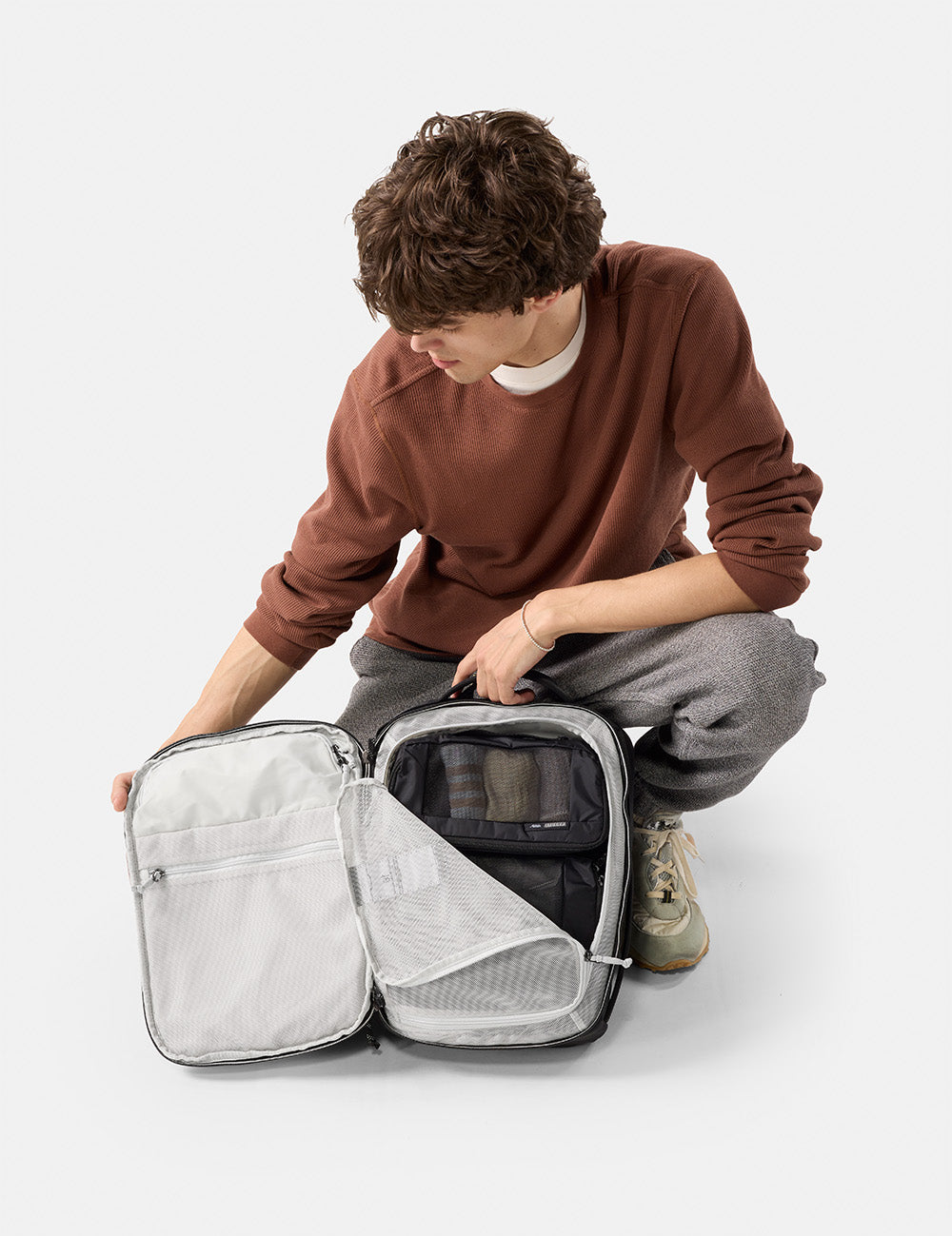 Person unpacking a  travel bag on a white background