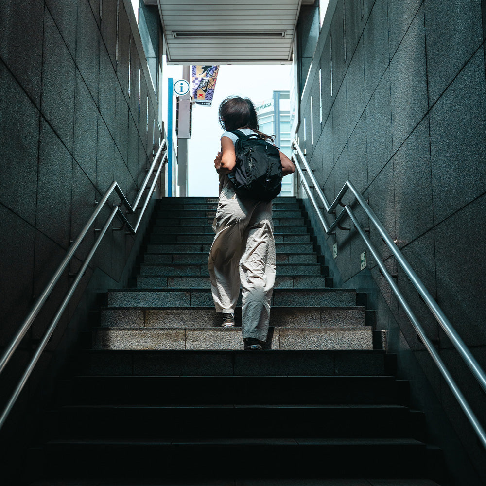 person walking up subway stairwell