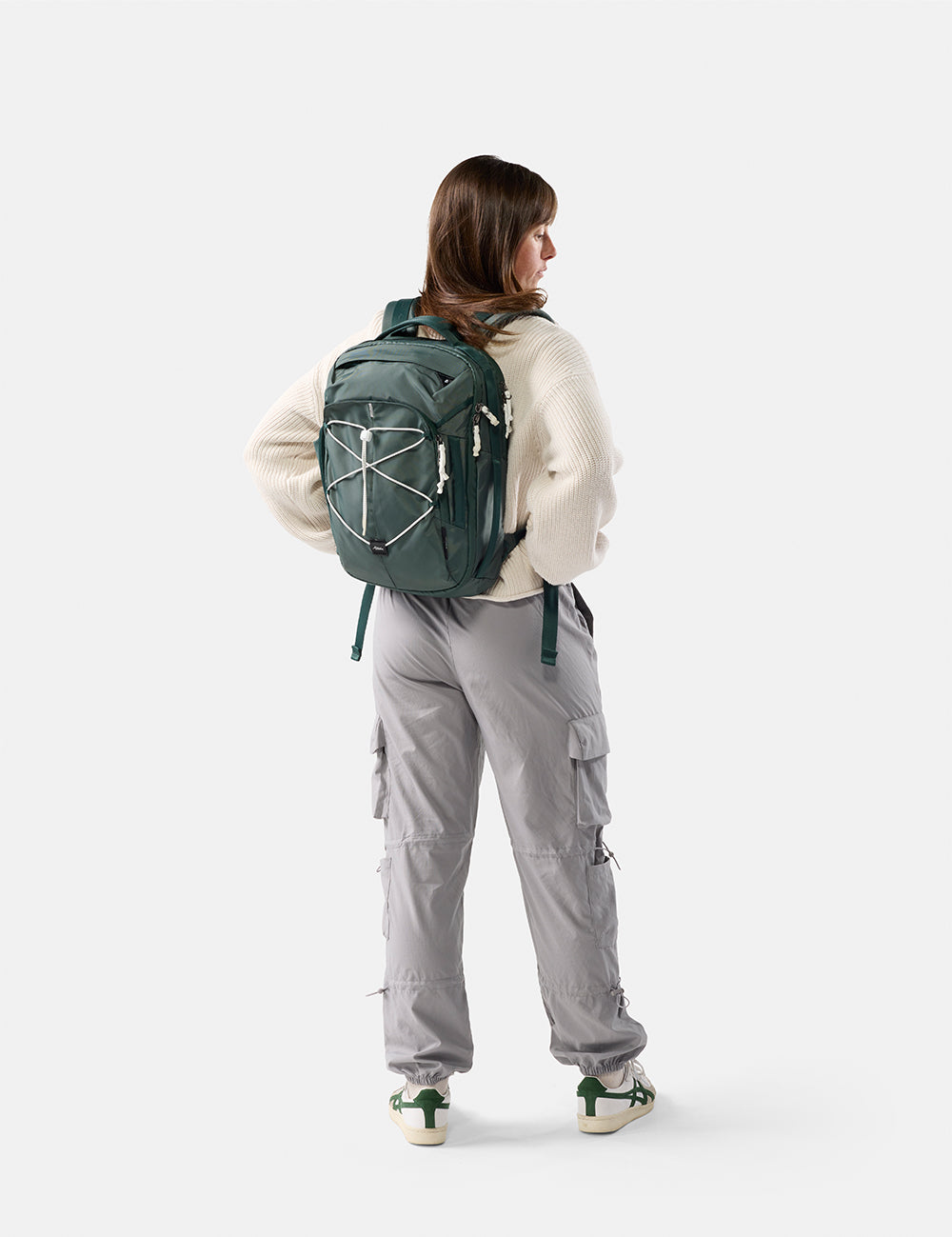Person wearing a green backpack on a white background