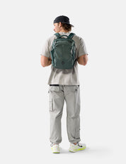 Person wearing a green backpack on a white background