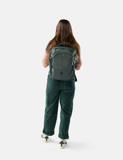 Person wearing a green backpack and green pants on a white background