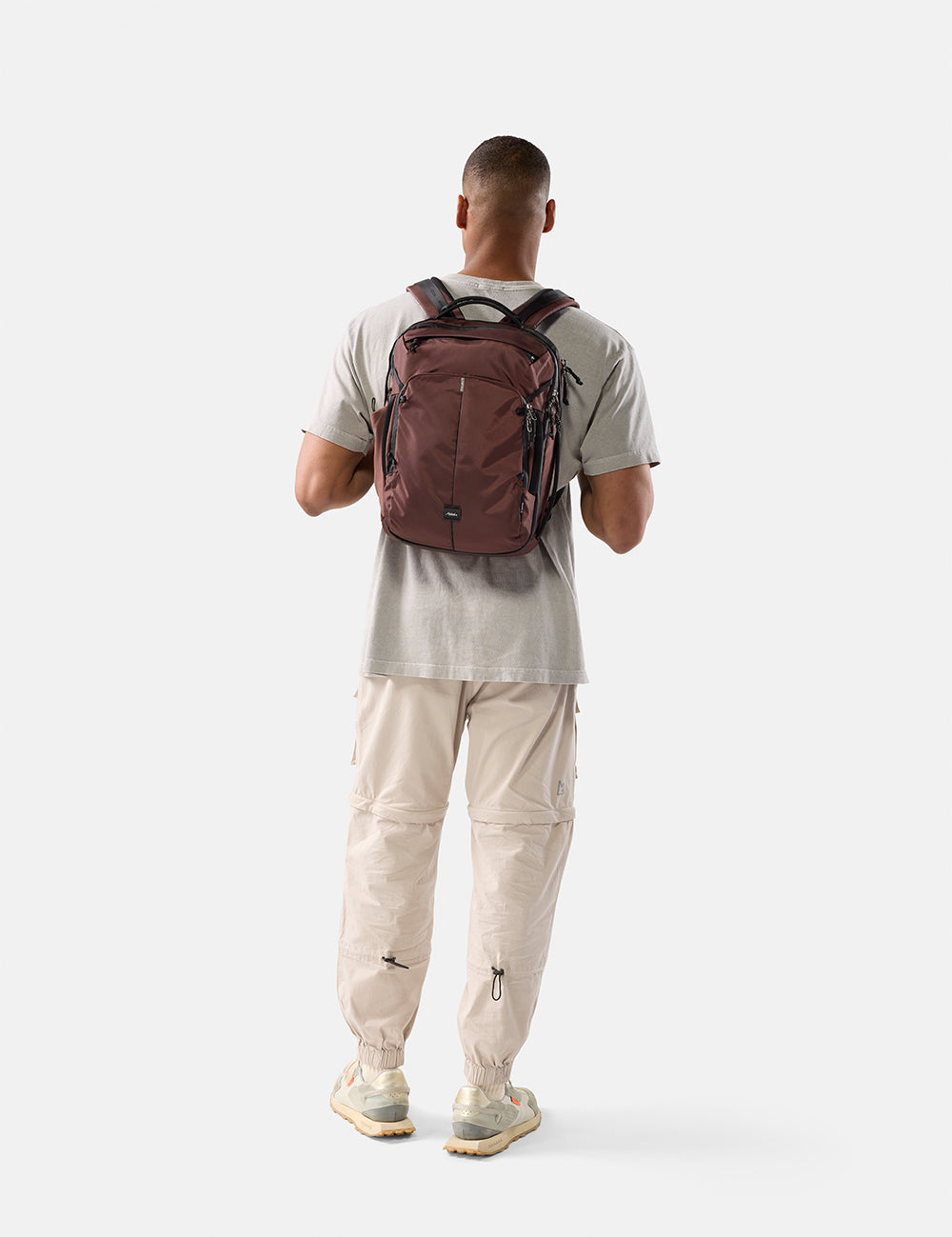Person wearing a garnet backpack on a white background