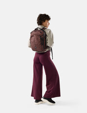 Person wearing a garnet  backpack and garnet  pants on a white background