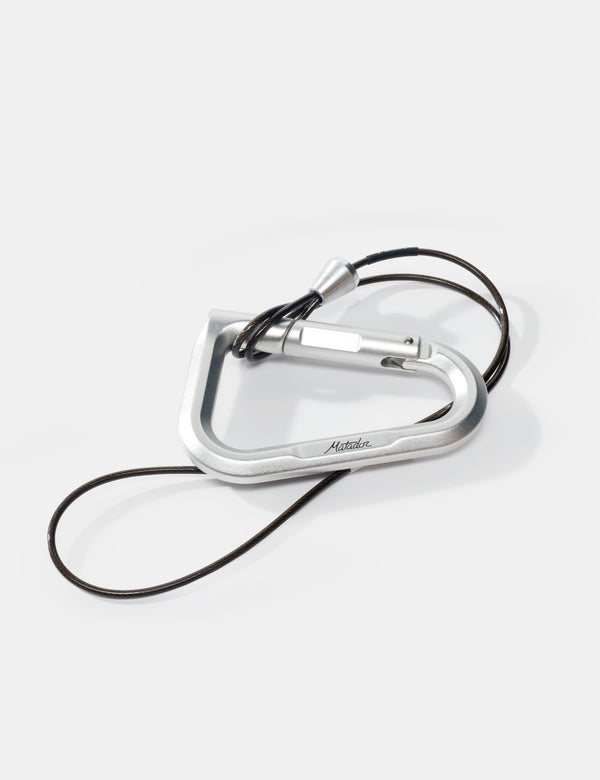 Silver carabiner with a black cord on a white background
