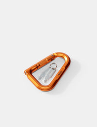 Orange carabiner with a key on a white background