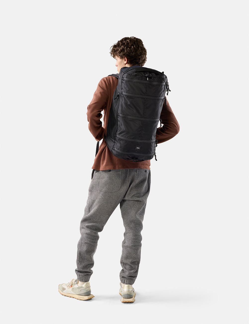 Person wearing a black backpack on a white background