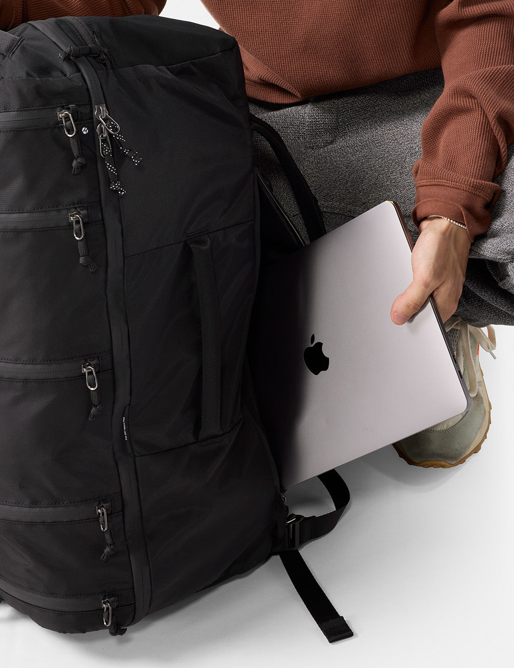 pulling laptop out of black backpack