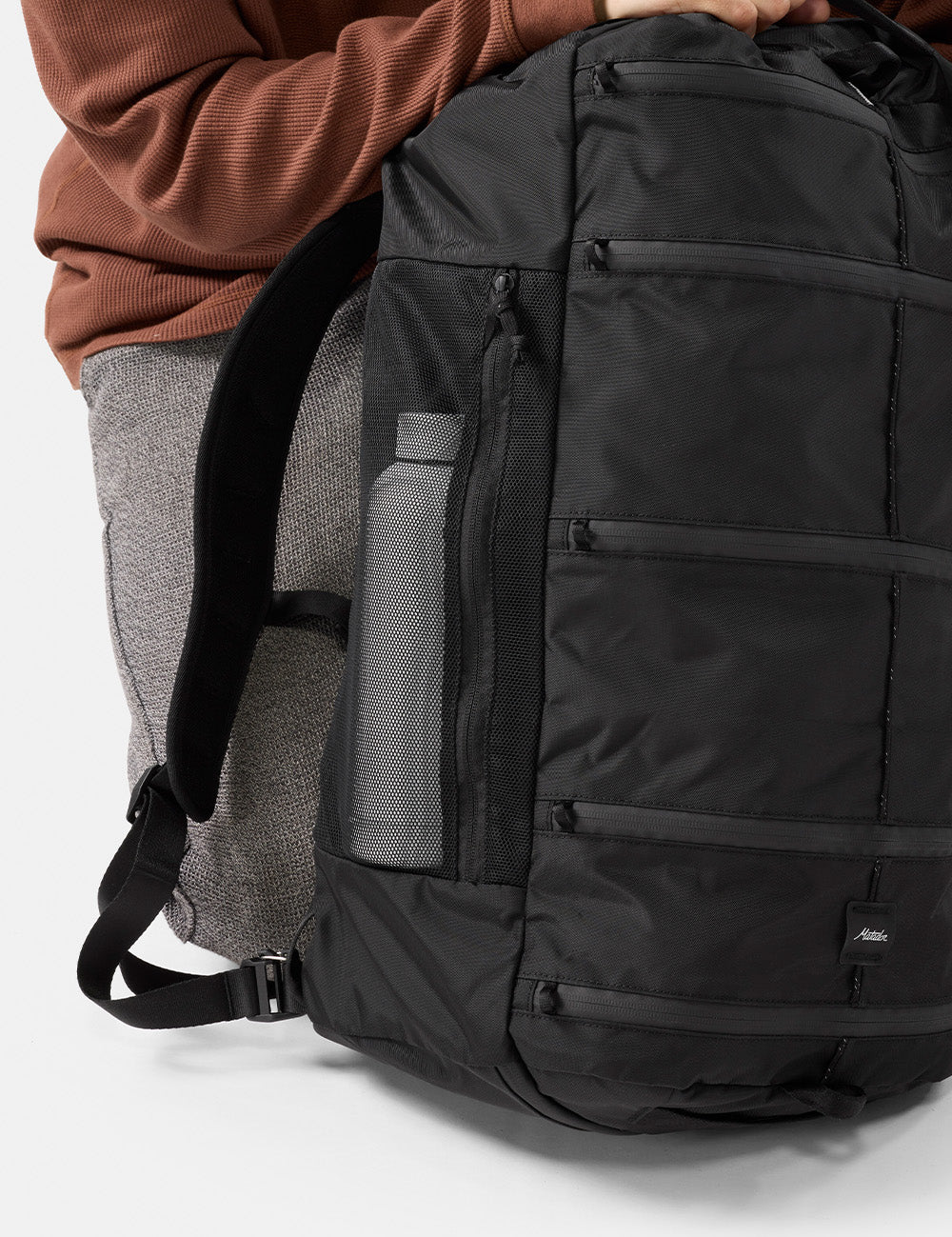 water bottle in mesh side pocket of black backpack