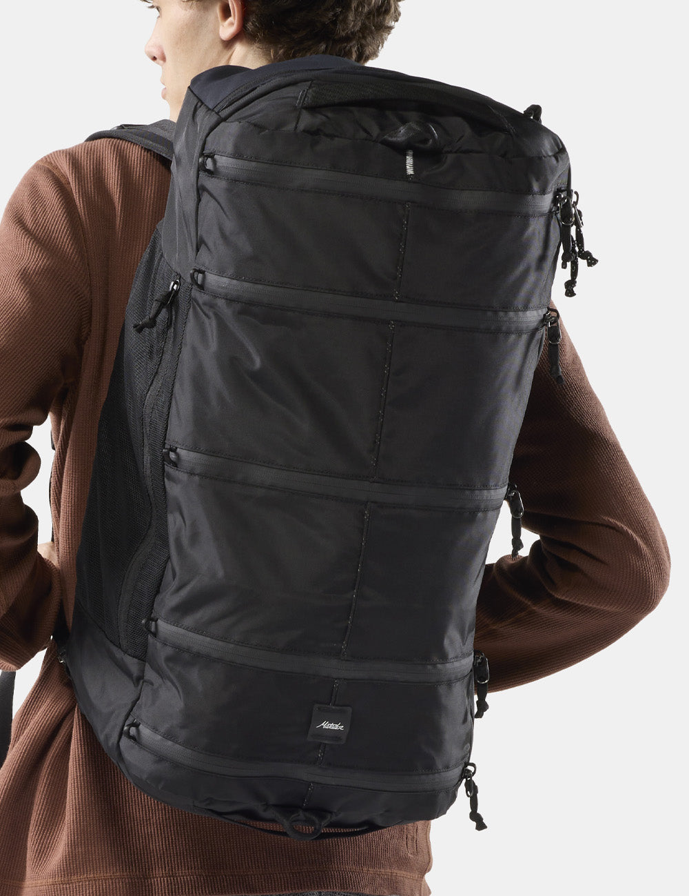 person wearing black segmented backpack