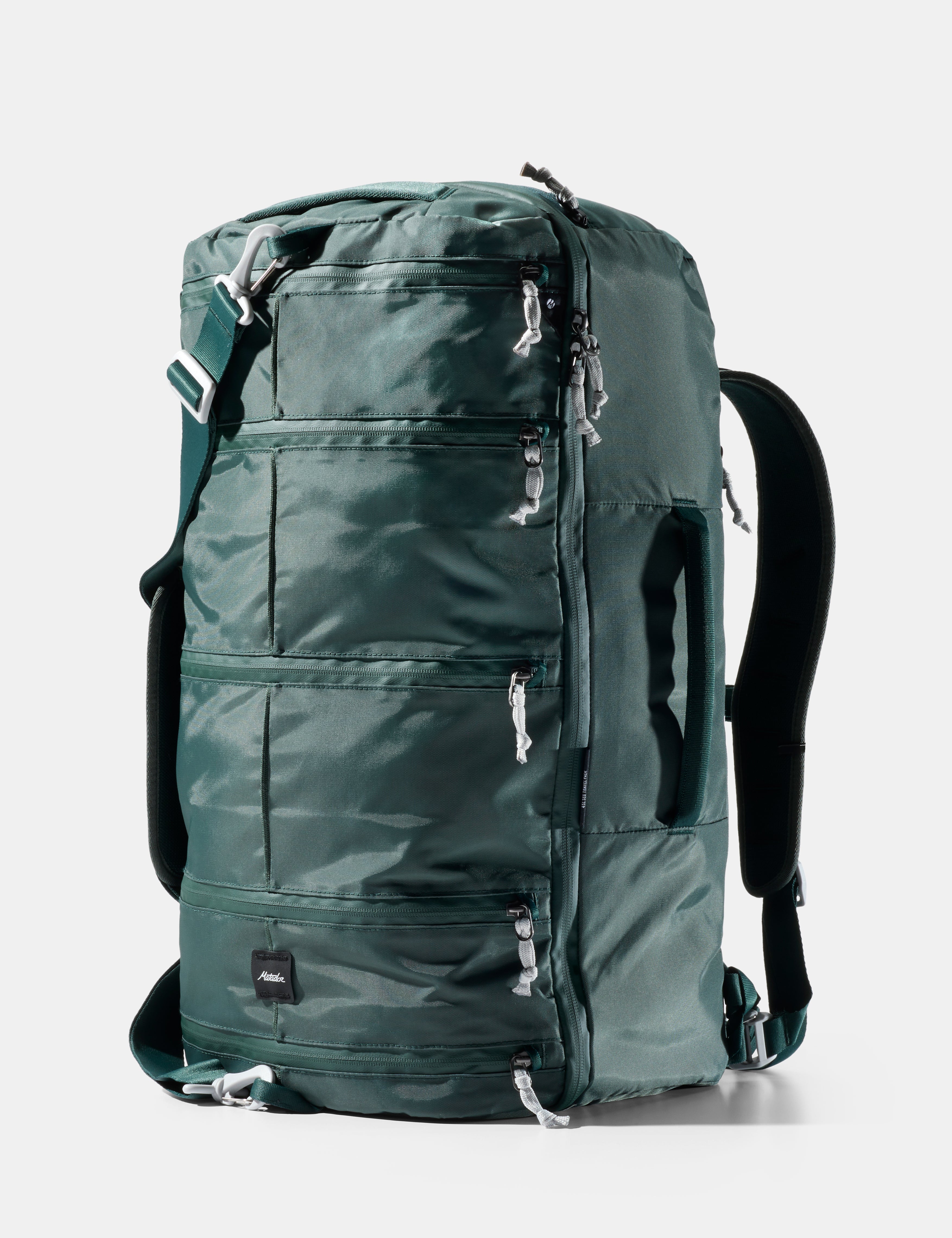 Green backpack with multiple zippers on a white background