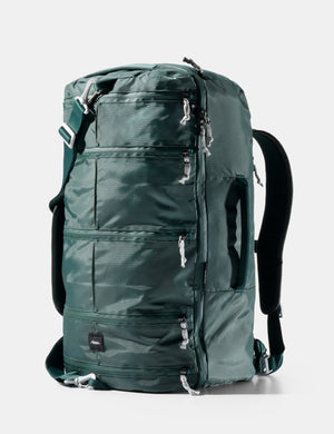 Green backpack with multiple zippers on a white background