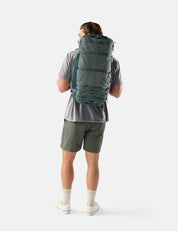 Person wearing a green backpack on a white background