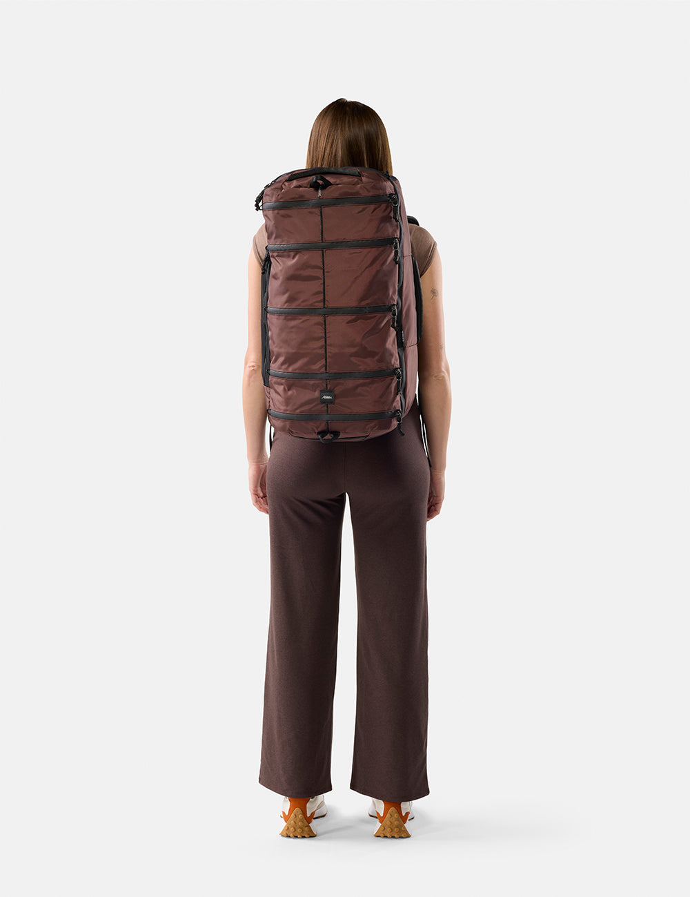 Person wearing a large Garnet  backpack on a white background