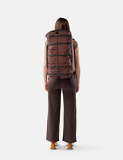 Person wearing a large Garnet  backpack on a white background