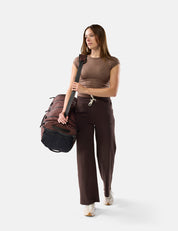 Woman holding a duffel bag against a white background