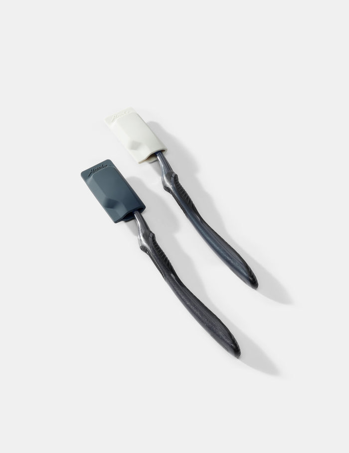 two toothbrushes and caps on a white background