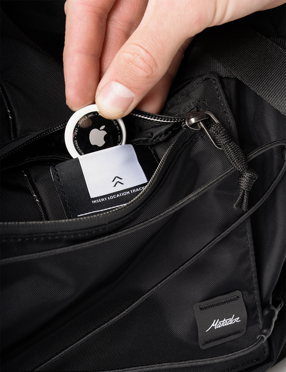 air tag being place in black pocket
