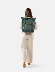 Person wearing a green tote pack on a white background