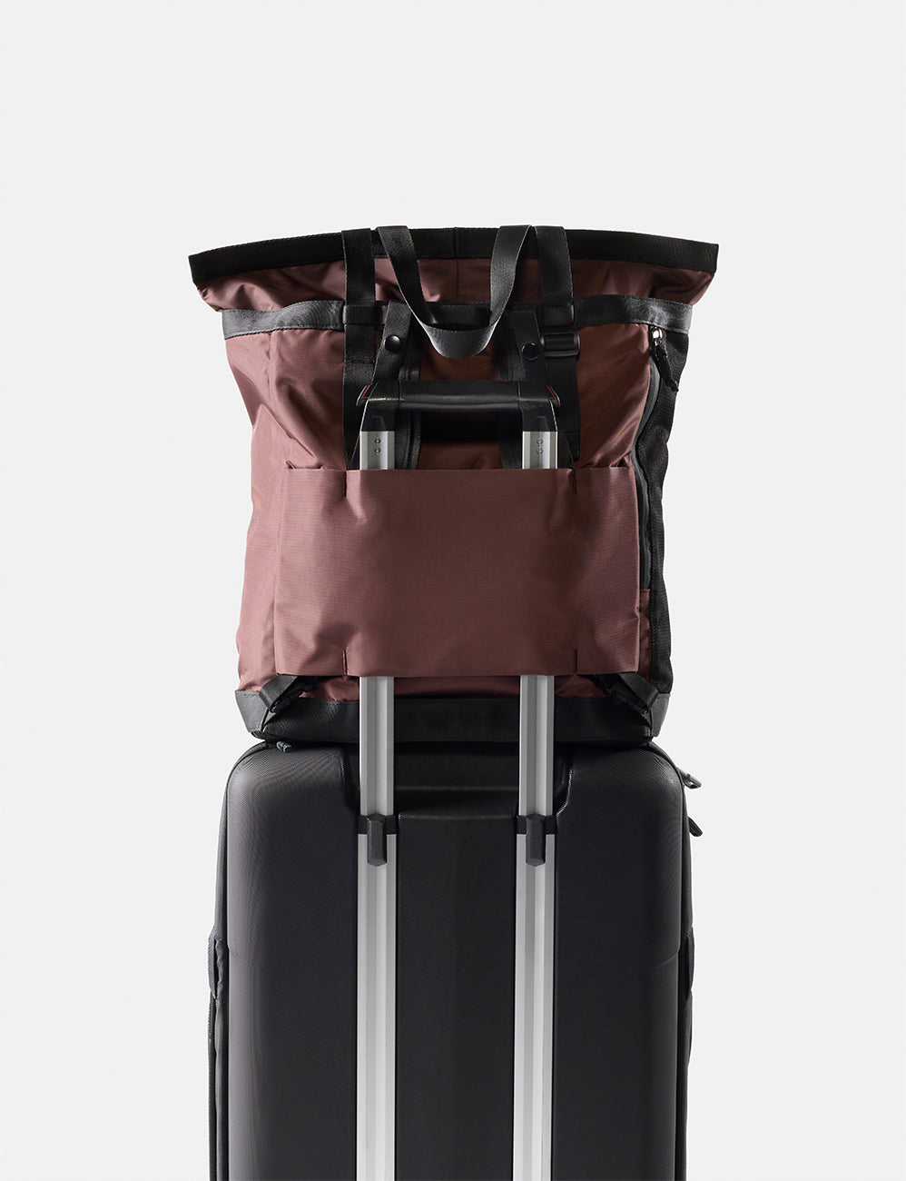Black suitcase with a garnet backpack on top against a white background