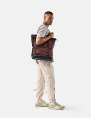 Person carrying a garnet backpack on a white background