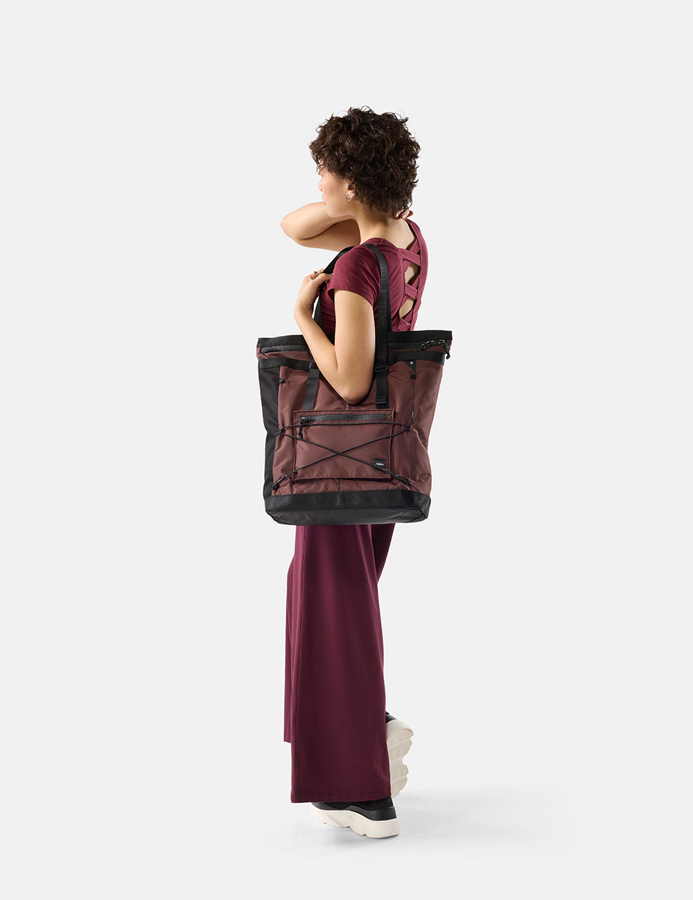Woman carrying a garnet tote on a white background