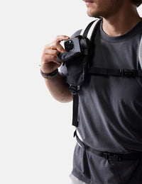 Person wearing a black backpack with a white background