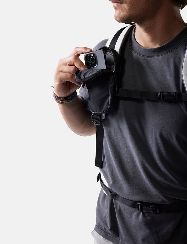 Person wearing a black backpack with a white background