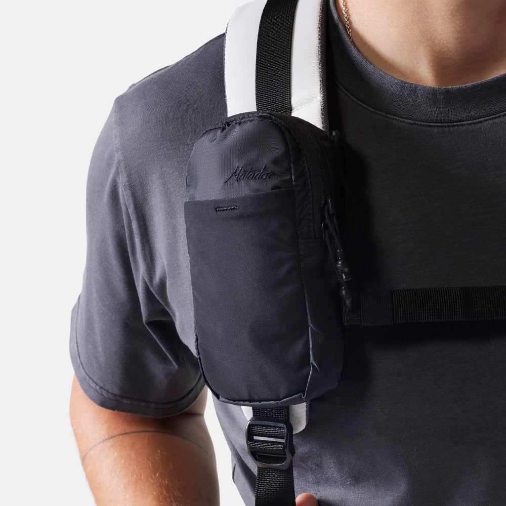 Man wearing a white backpack with straps over his shoulders on a white background