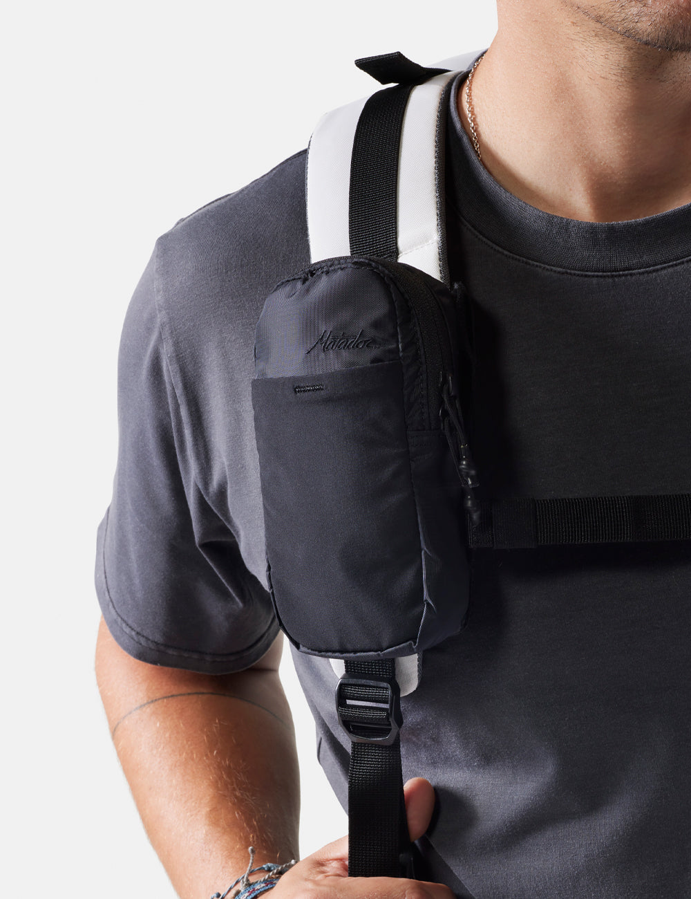 Man wearing a white backpack with straps over his shoulders on a white background