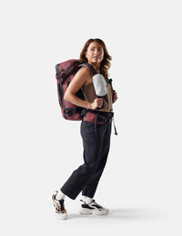 Person wearing a red and black  backpack with white pouch on a white background