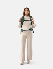 Woman wearing a green backpack on a white background