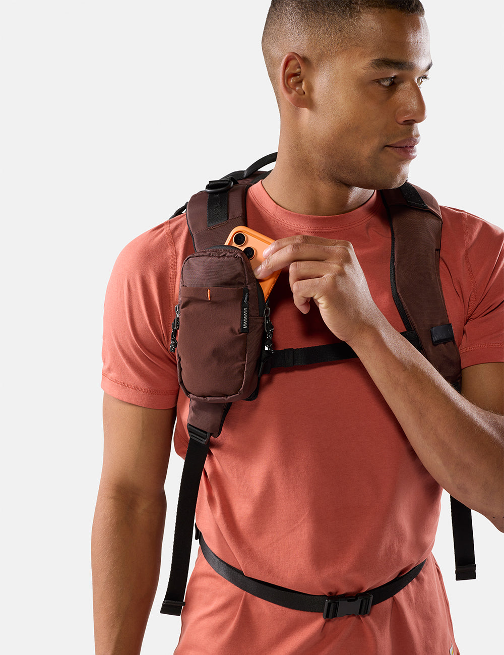 Man wearing a garnet backpack with a white background