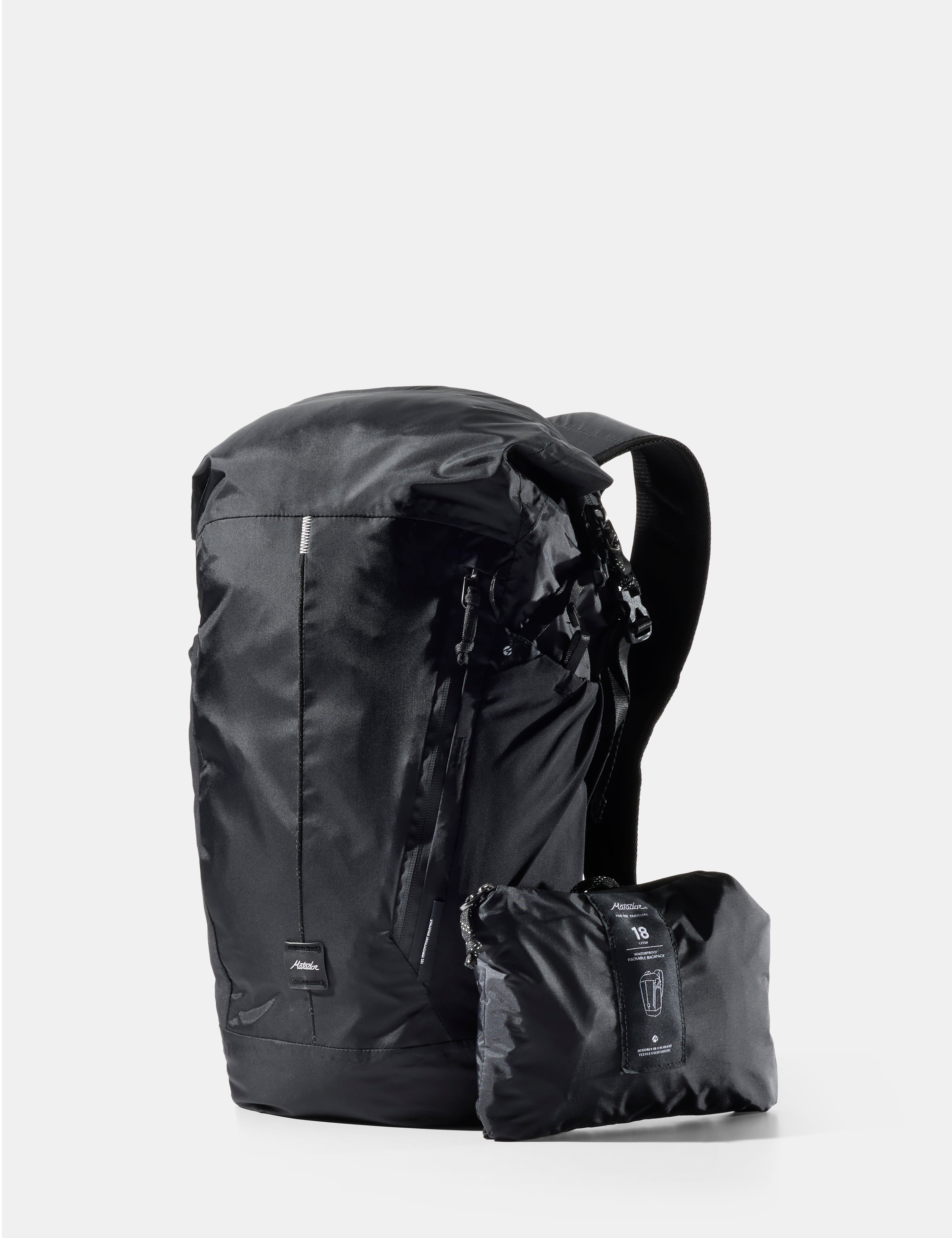 Black backpack with a smaller black pack attached on a white background