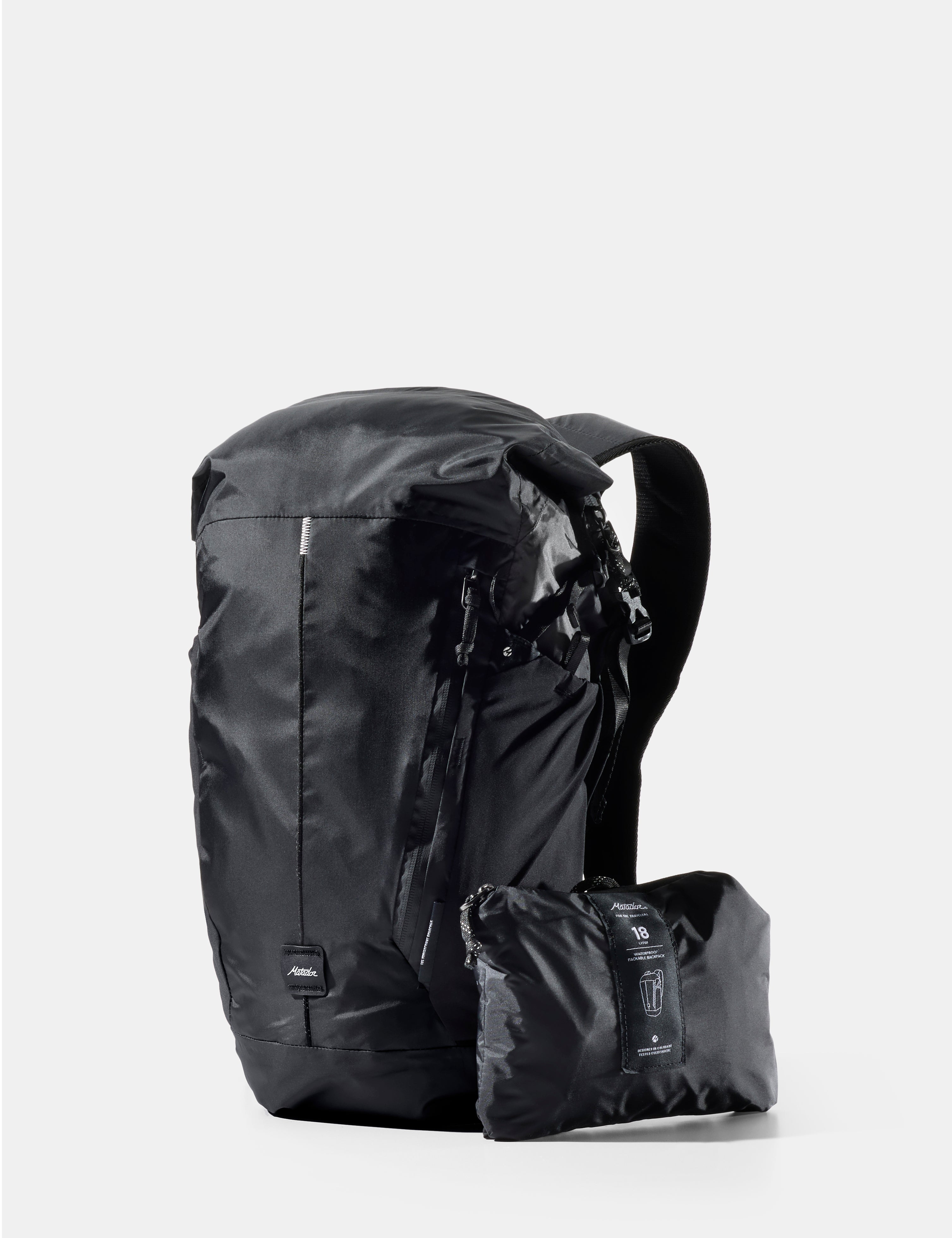 Black backpack with a smaller black pack attached on a white background