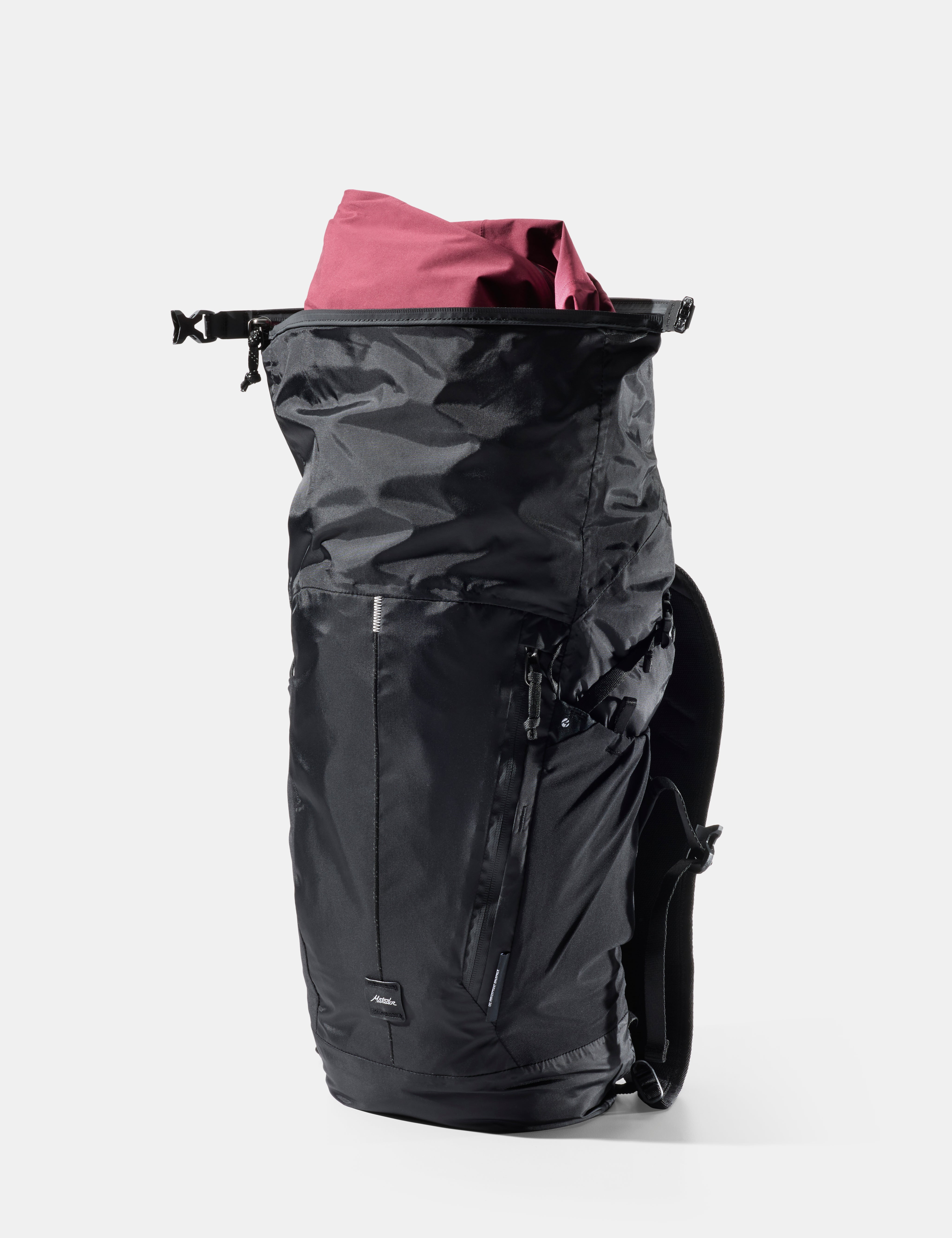 Black backpack with a red item coming out the top against a white background