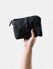Hand holding a black compression bag with a visible brand label on a light gray background