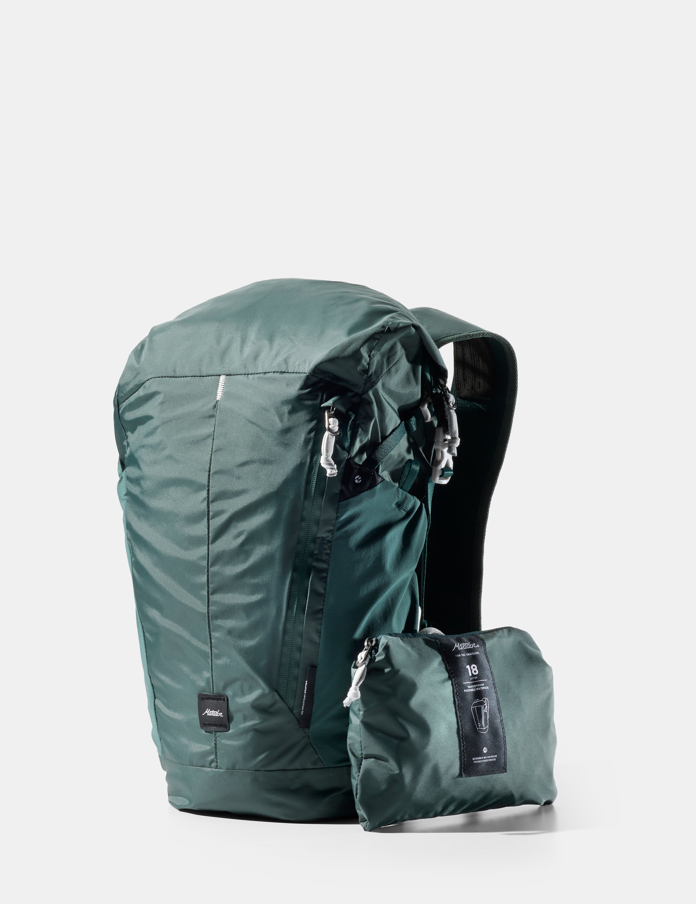 Green backpack with a smaller green pouch on a light gray background